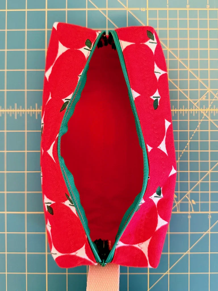 The apple pouch open to reveal a matching red fabric lining
