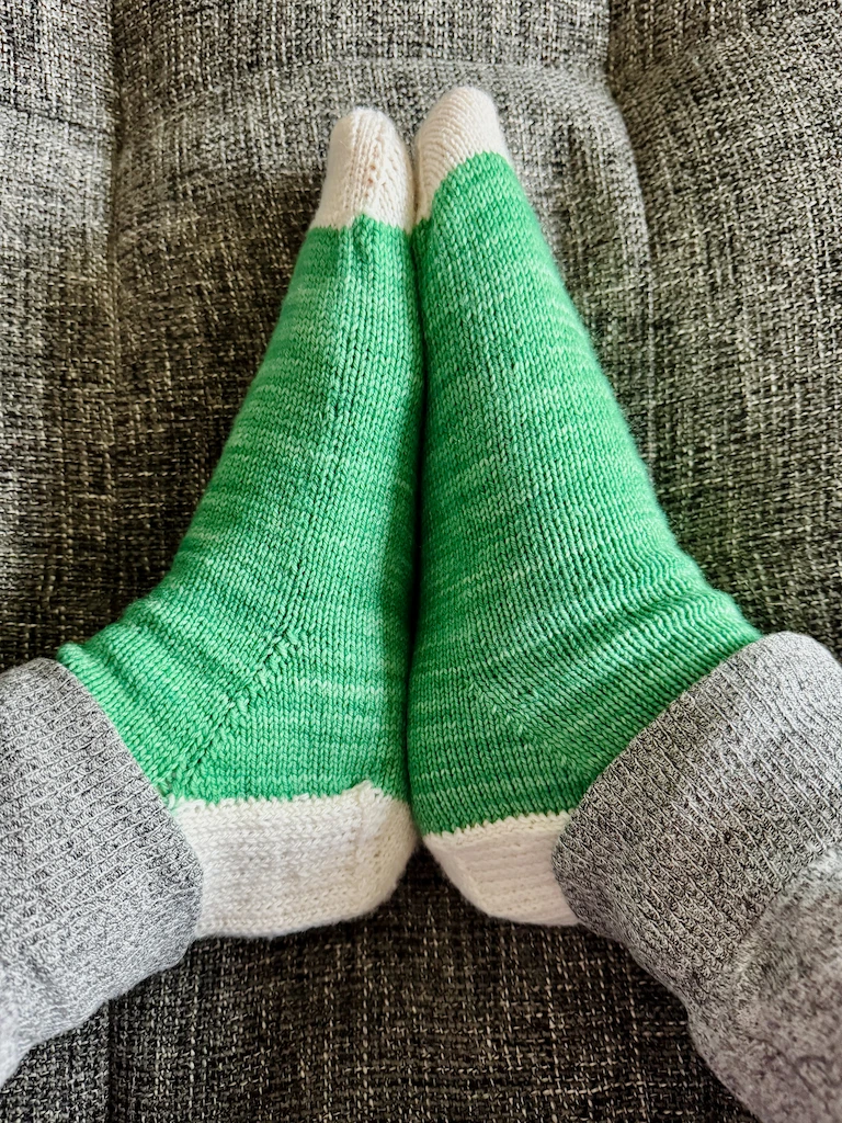 My feet in the socks, facing each other, so that you can also see that they have a light cream heel.