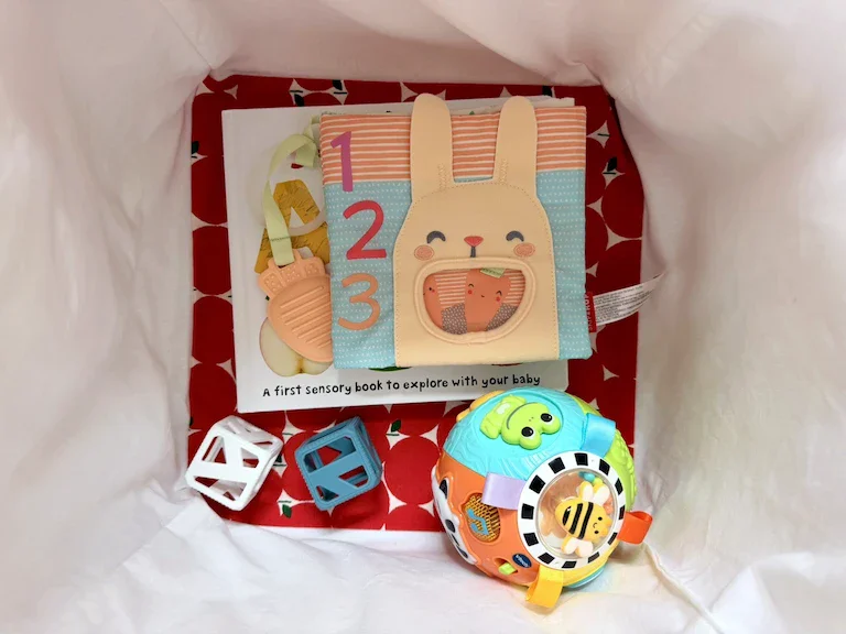 The interior of the apple bucket, again with patterned fabric in the bottom. This one shows an assortment of toys in the cube.